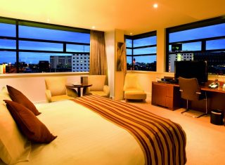 Bedroom with a panoramic view at dusk at Macdonald Manchester Hotel & Spa